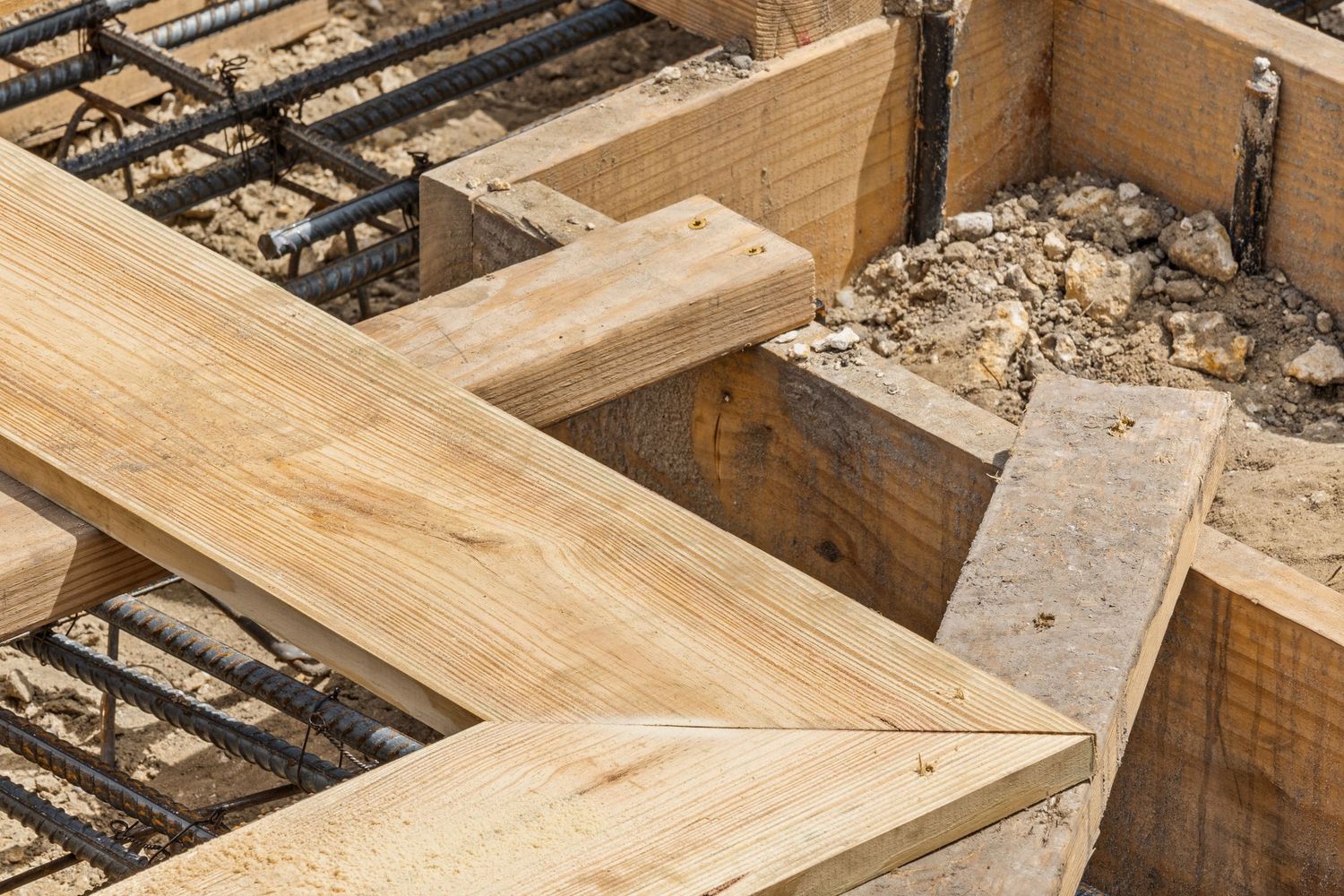 Close-up view of wooden floor joists and construction framing showing structural support details.