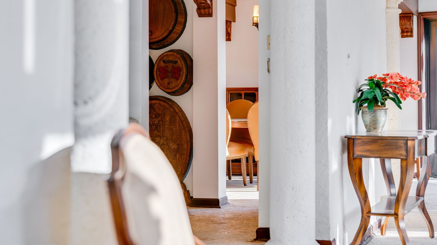 A modern white hallway with arched doorways and wooden doors features a minimalist design and natural lighting.