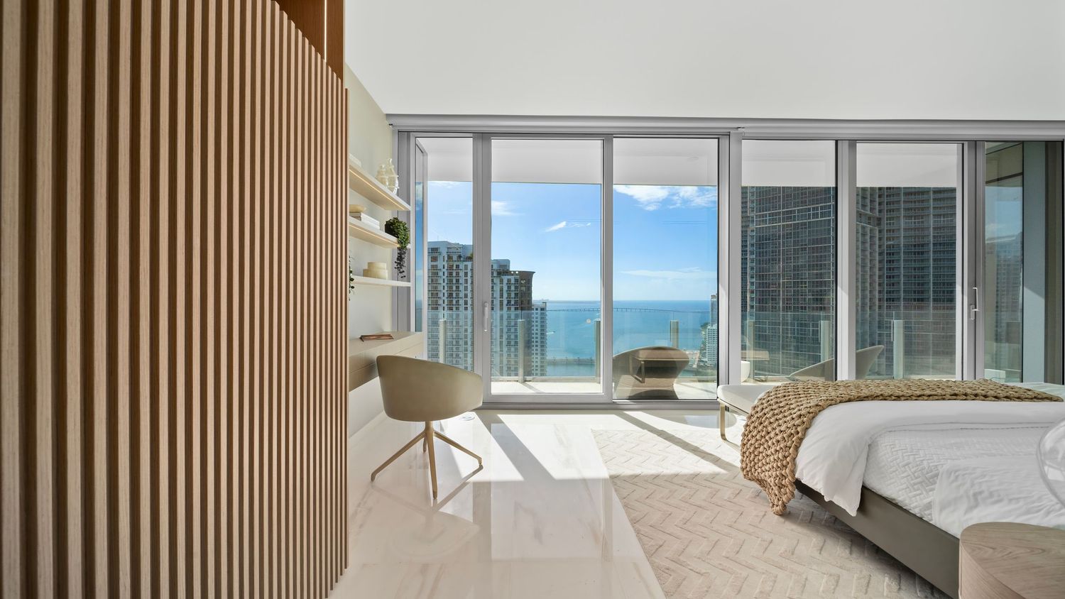 Modern luxury apartment interior with floor-to-ceiling windows, wood paneling, and panoramic city views.