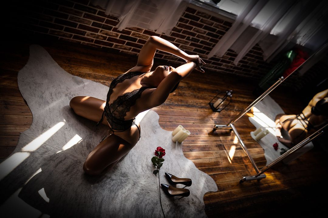 Artistic boudoir scene with dramatic shadows and lighting in an industrial setting.