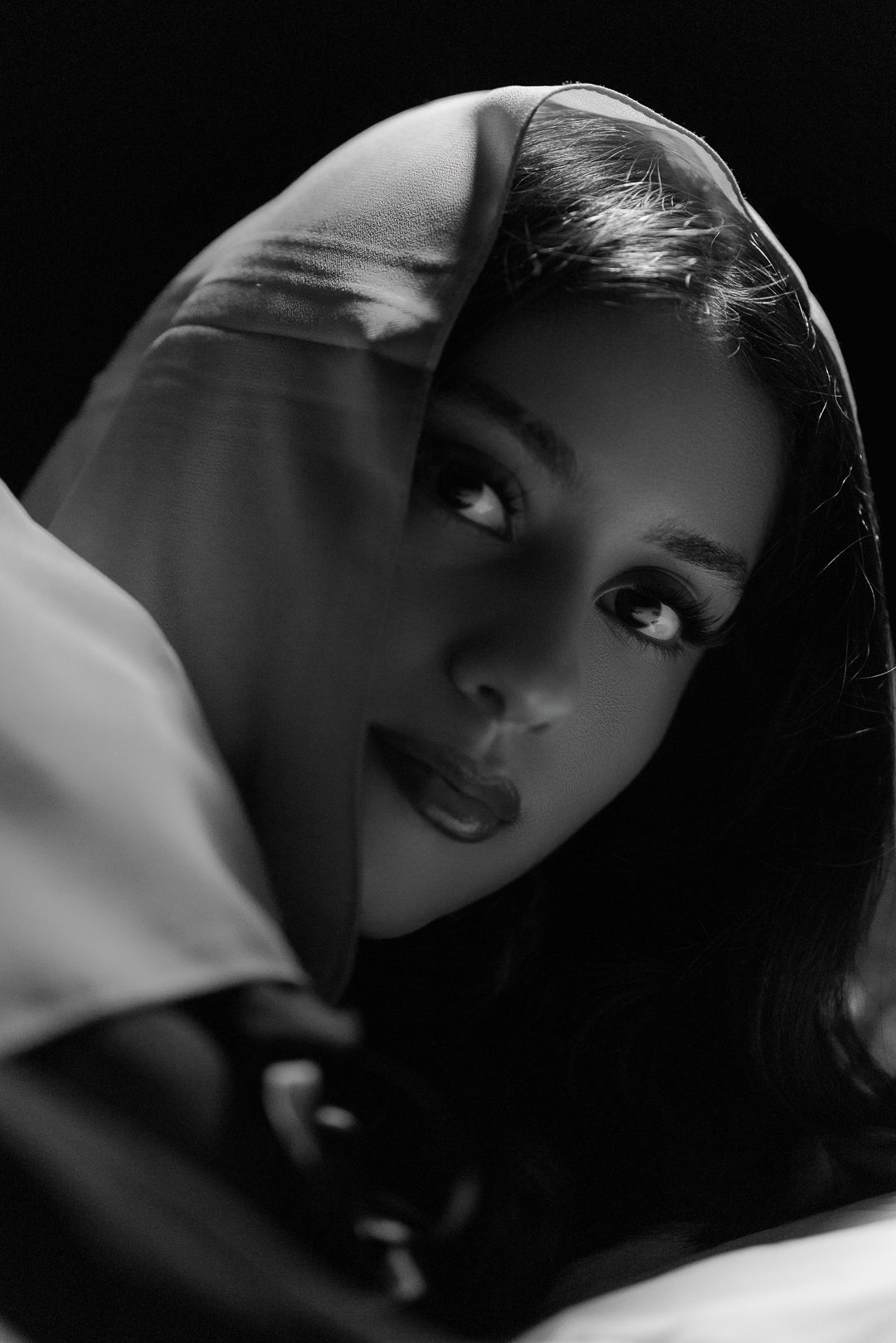 Artistic black and white portrait with dramatic side lighting.