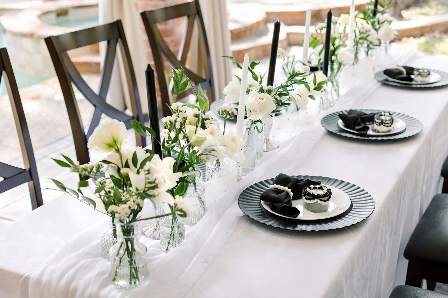 Elegant white tablescape with floral centerpieces and place settings for a formal event.