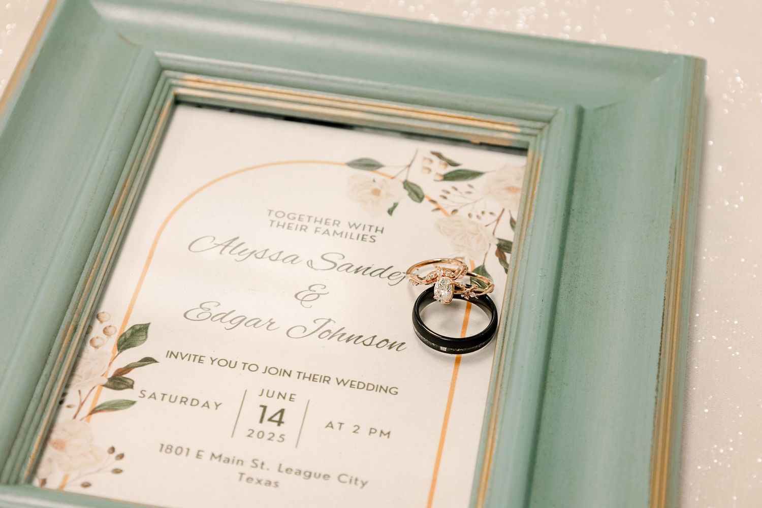 Wedding invitation details framed in mint green frames displayed on a wall.