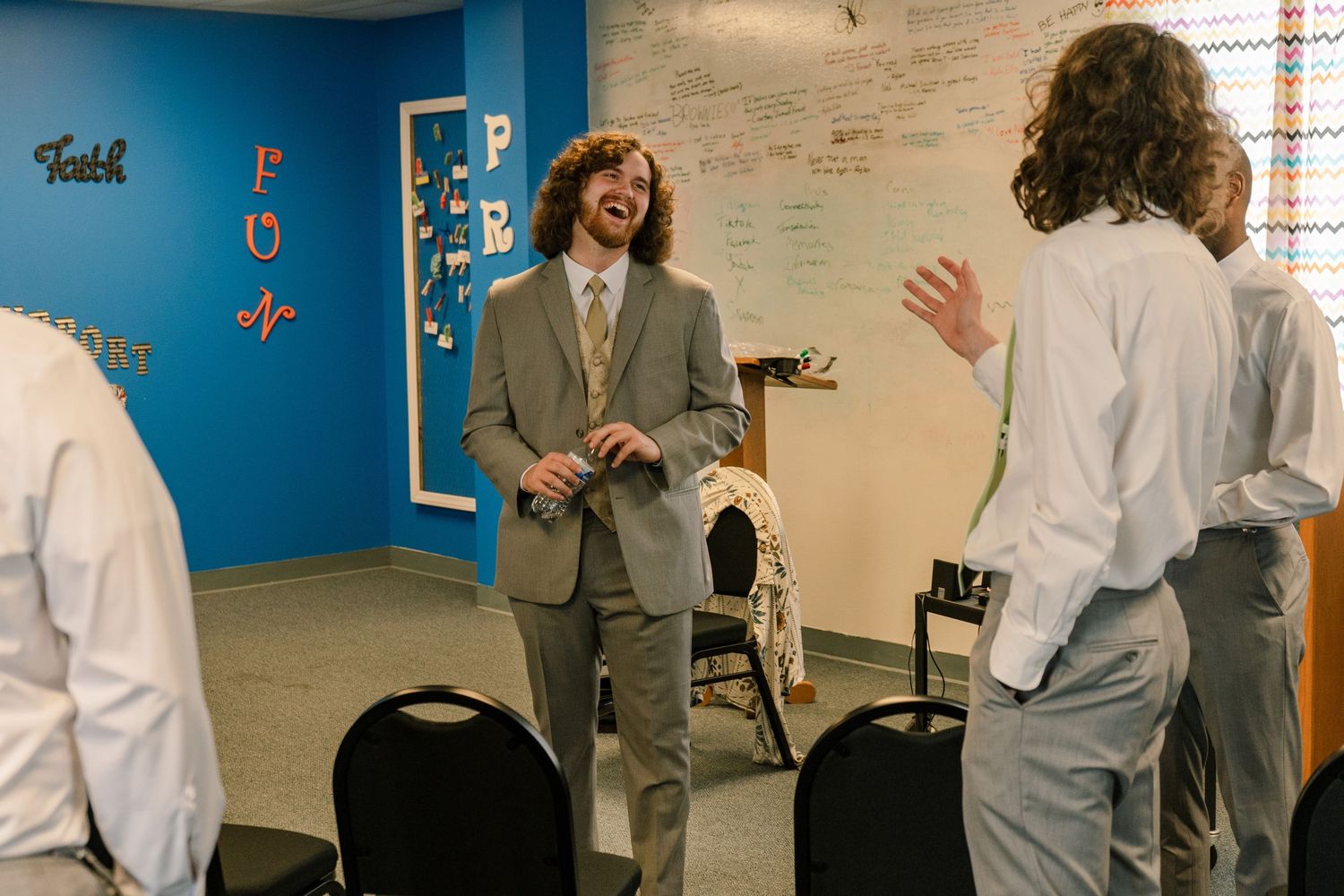 People enjoying humorous moments in a room decorated with 'Love' signage.
