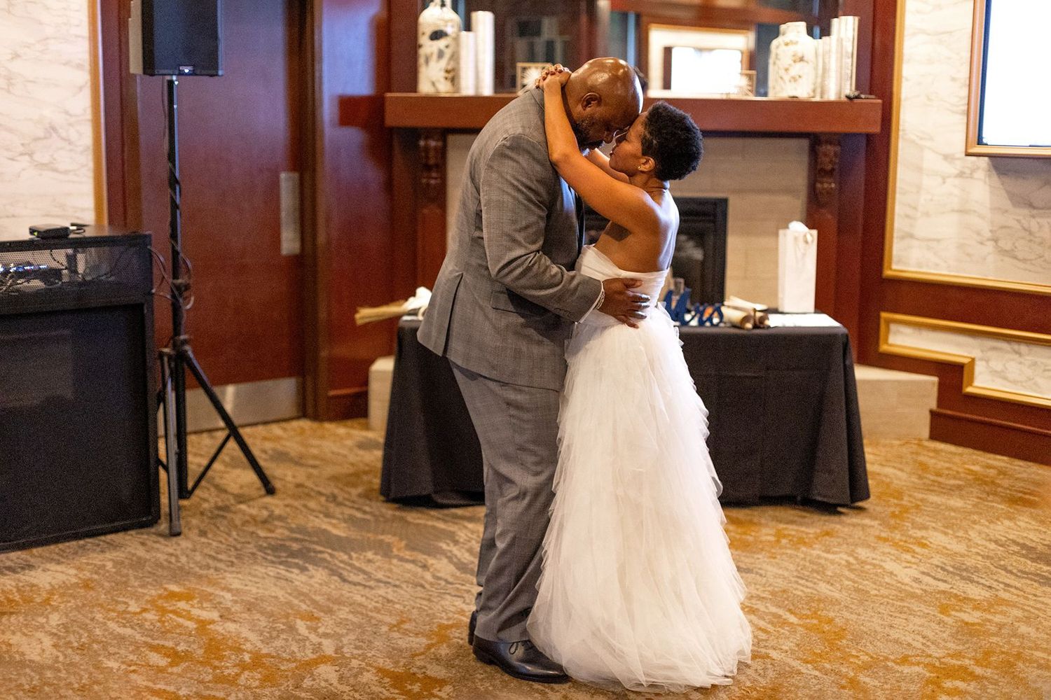 Bride and groom share emotional first dance embrace at wedding reception.