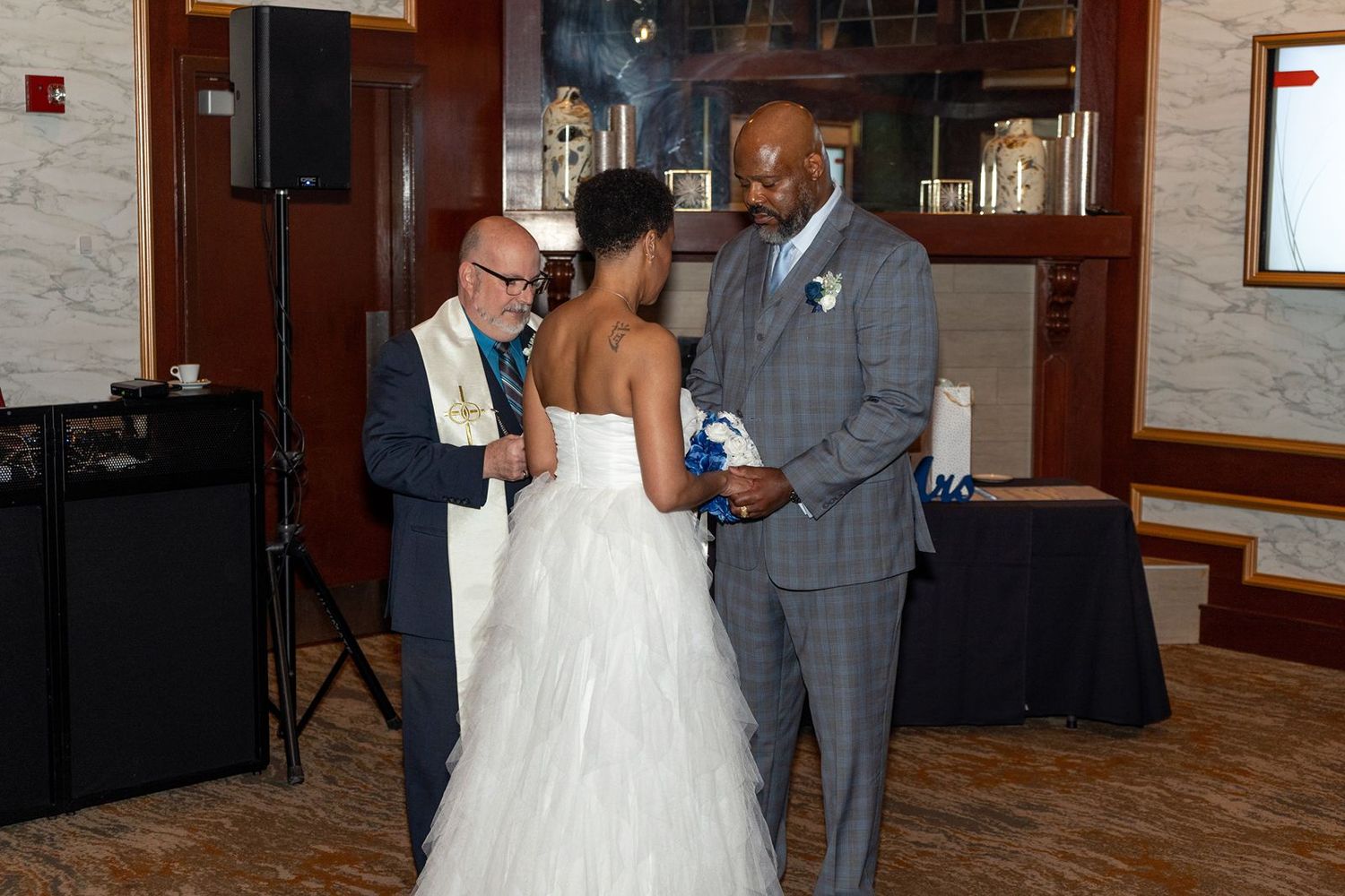 Bride and groom exchange vows during indoor wedding ceremony with officiant.