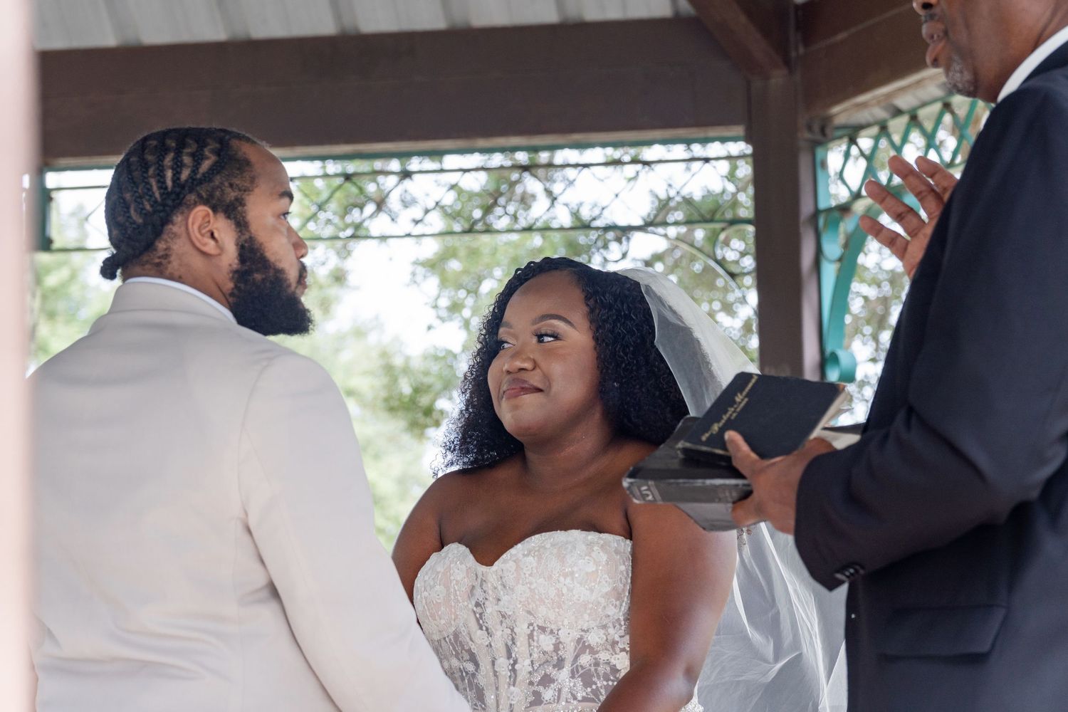 Wedding ceremony moments captured under a covered outdoor pavilion.