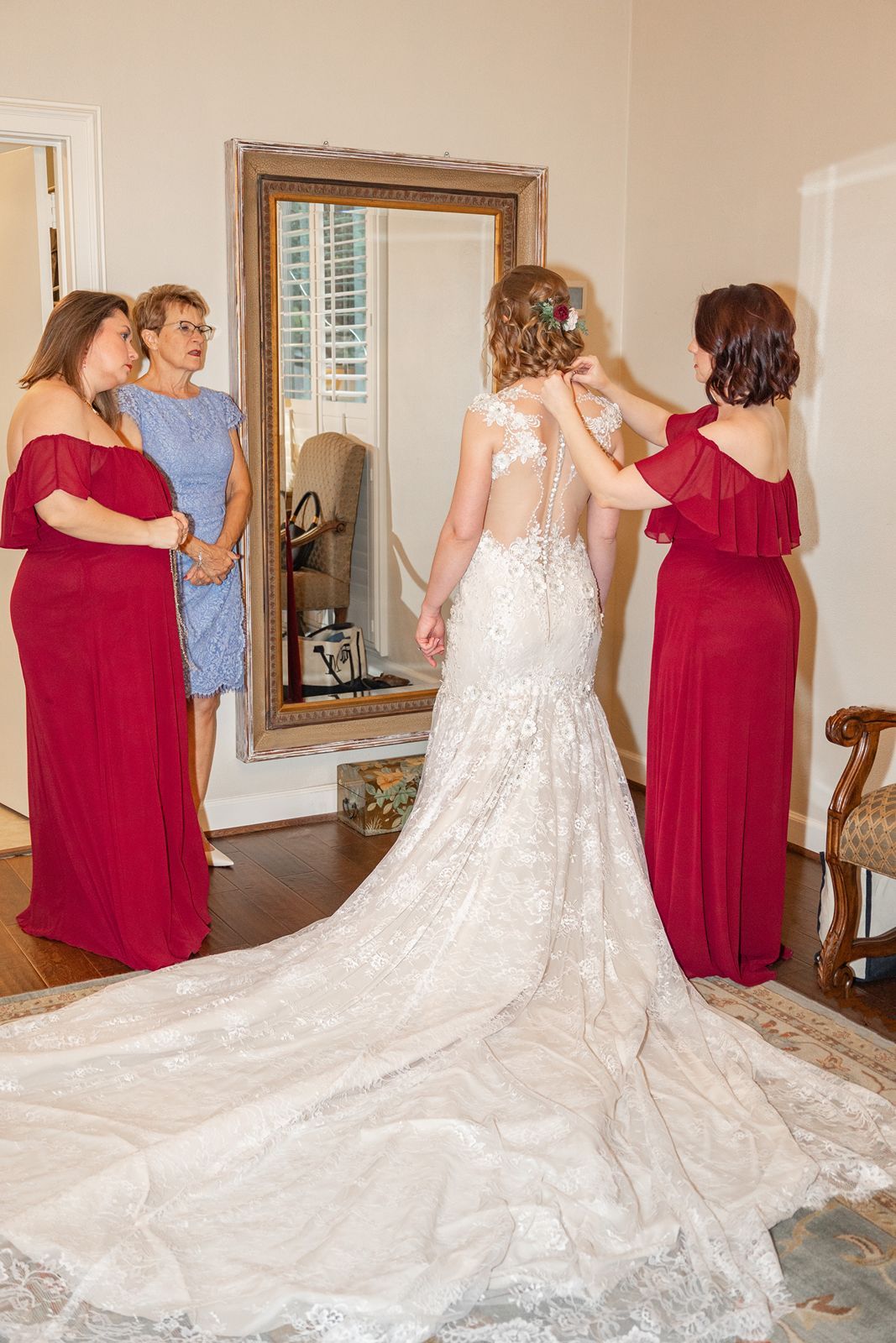 A series of photos showing a bride in a flowing white lace gown with a long train being helped by someone in burgundy.