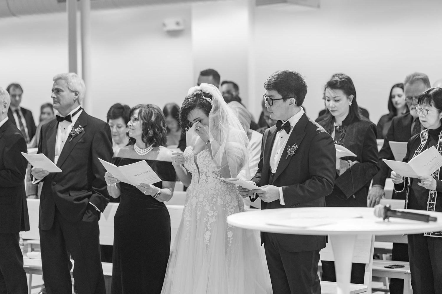 Black and white panoramic photo showing guests dancing and mingling at an elegant wedding reception.