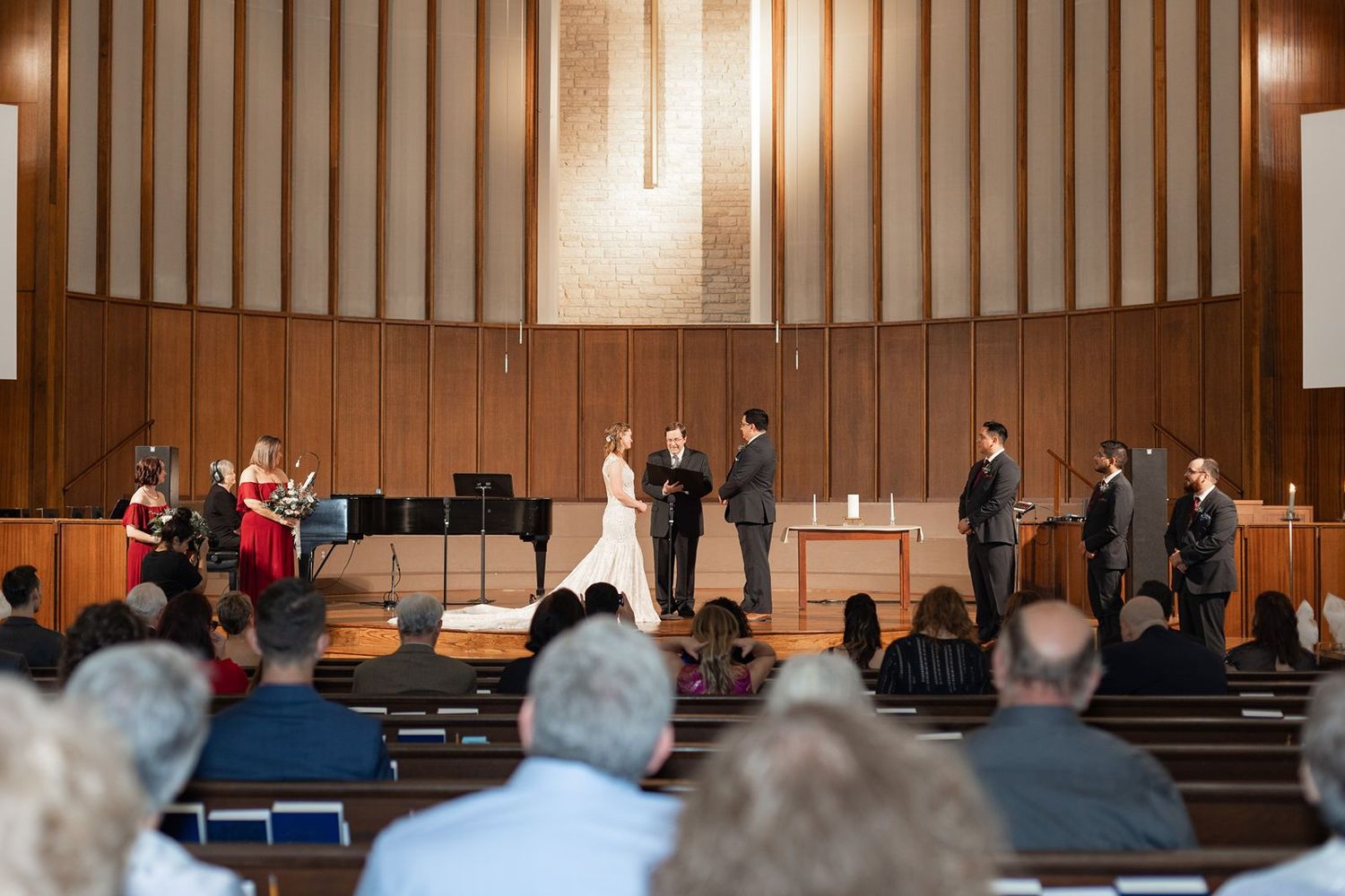 View of an auditorium interior with wood paneled walls and rows of audience seating.