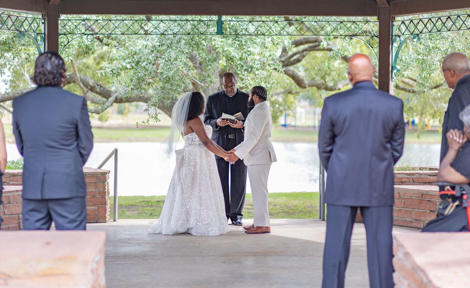 Wedding ceremony setup under a covered pavilion with guests seated.
