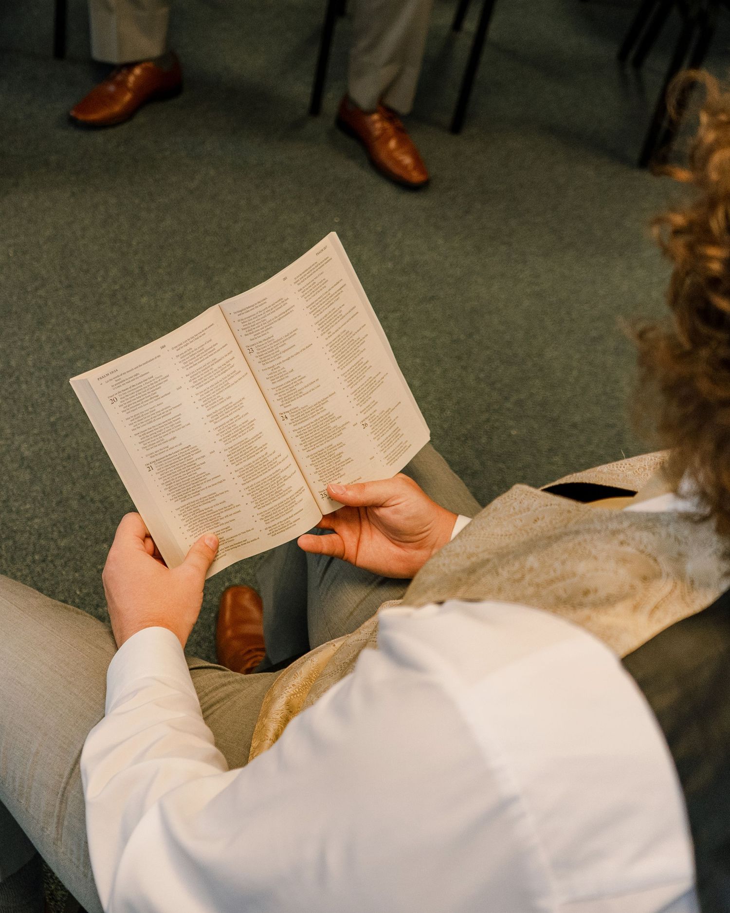 Close-up of hands holding open a small book or pamphlet.