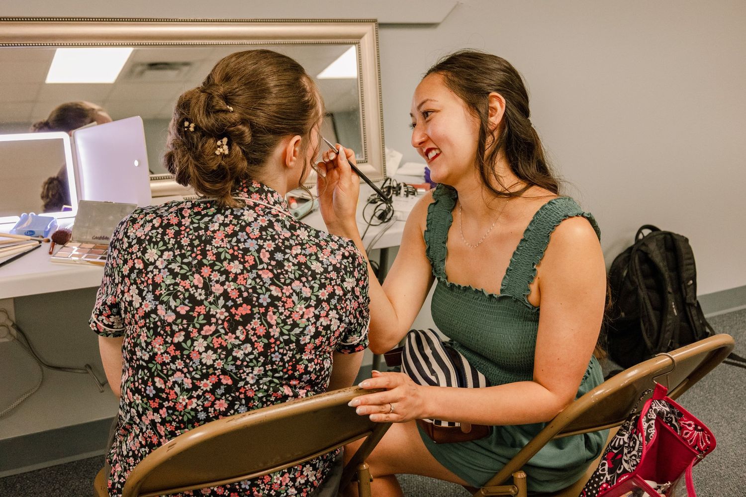 Wedding party members sharing joyful moments while getting ready in a bridal suite.