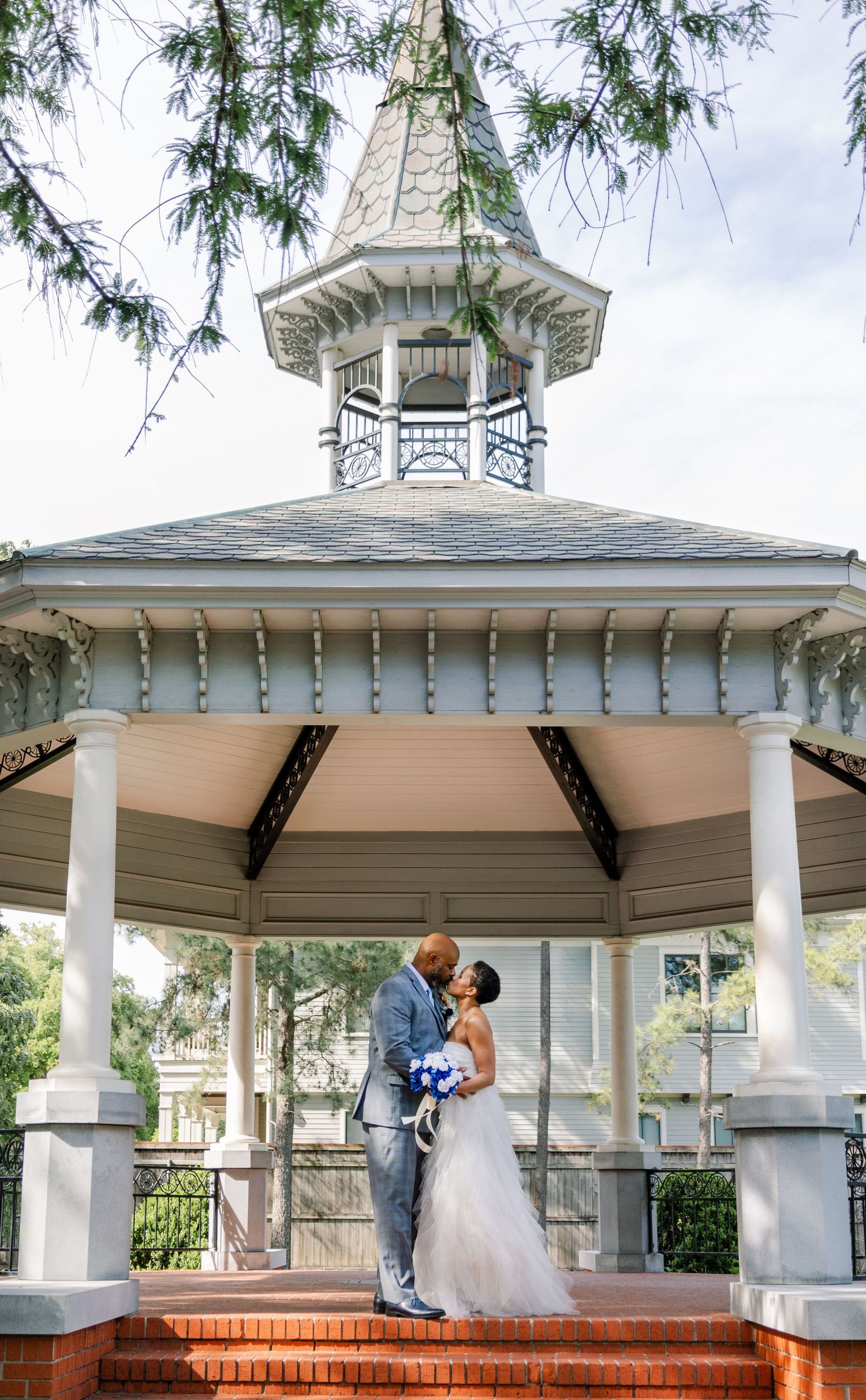 A white Victorian-style gazebo backdrop for a wedding ceremony with ornate details.