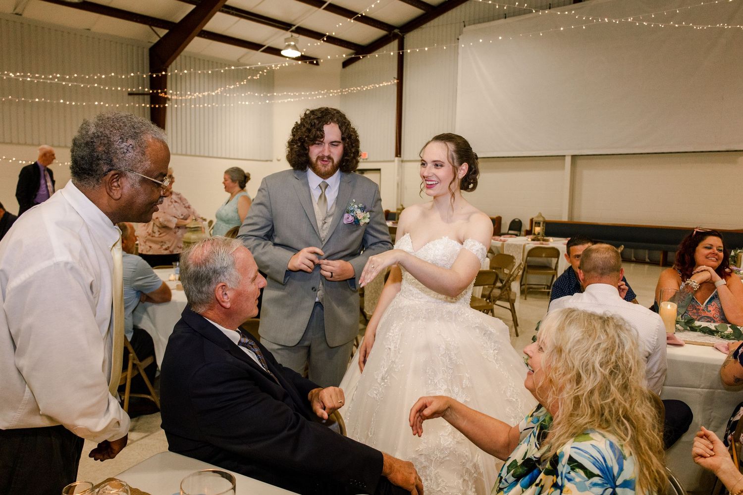 Wedding celebration with guests interacting at decorated reception tables.