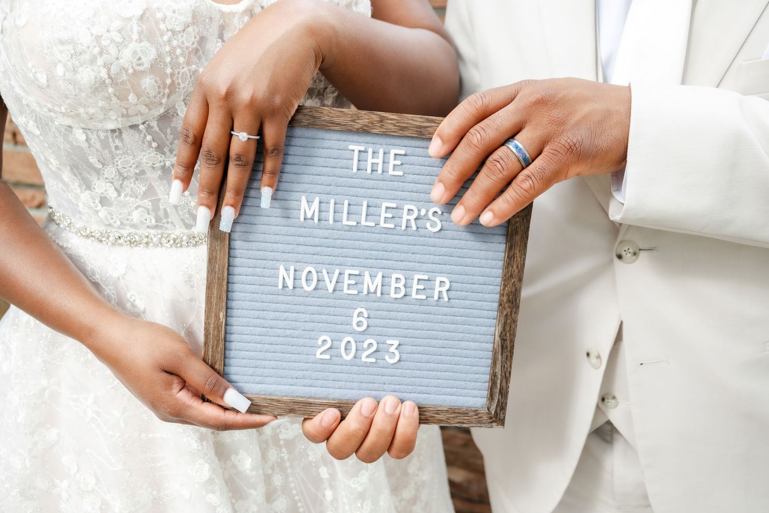 Close-up of hands holding letterboard signs at wedding celebration.