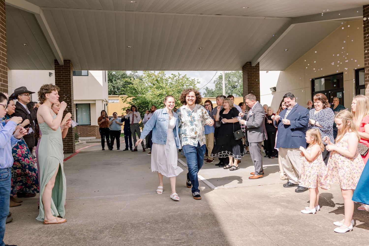 Wedding guests line a covered walkway to celebrate the newlyweds' exit.