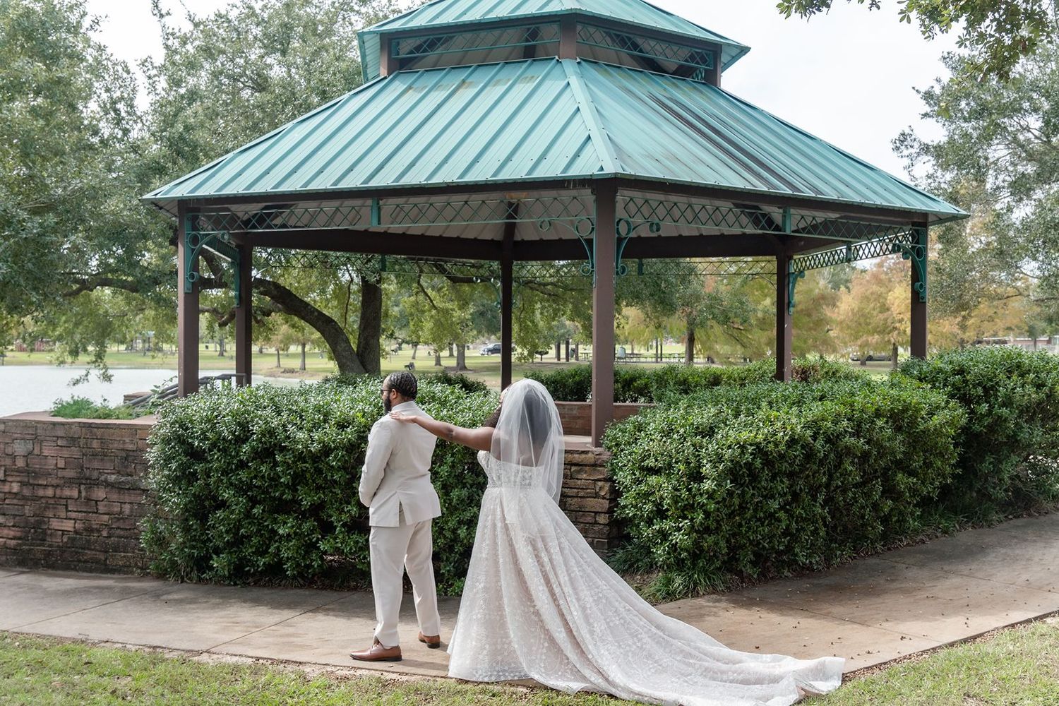 A series of green-roofed gazebos in a park setting with white fabric draping and decorative elements.