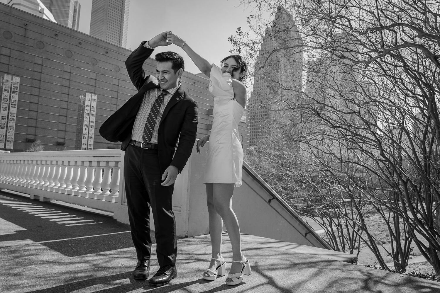 A black and white winter wedding scene shows a couple walking together in the snow.