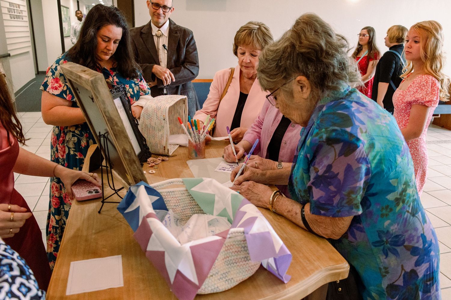 People gathered around tables doing a paper craft activity at a celebration event.