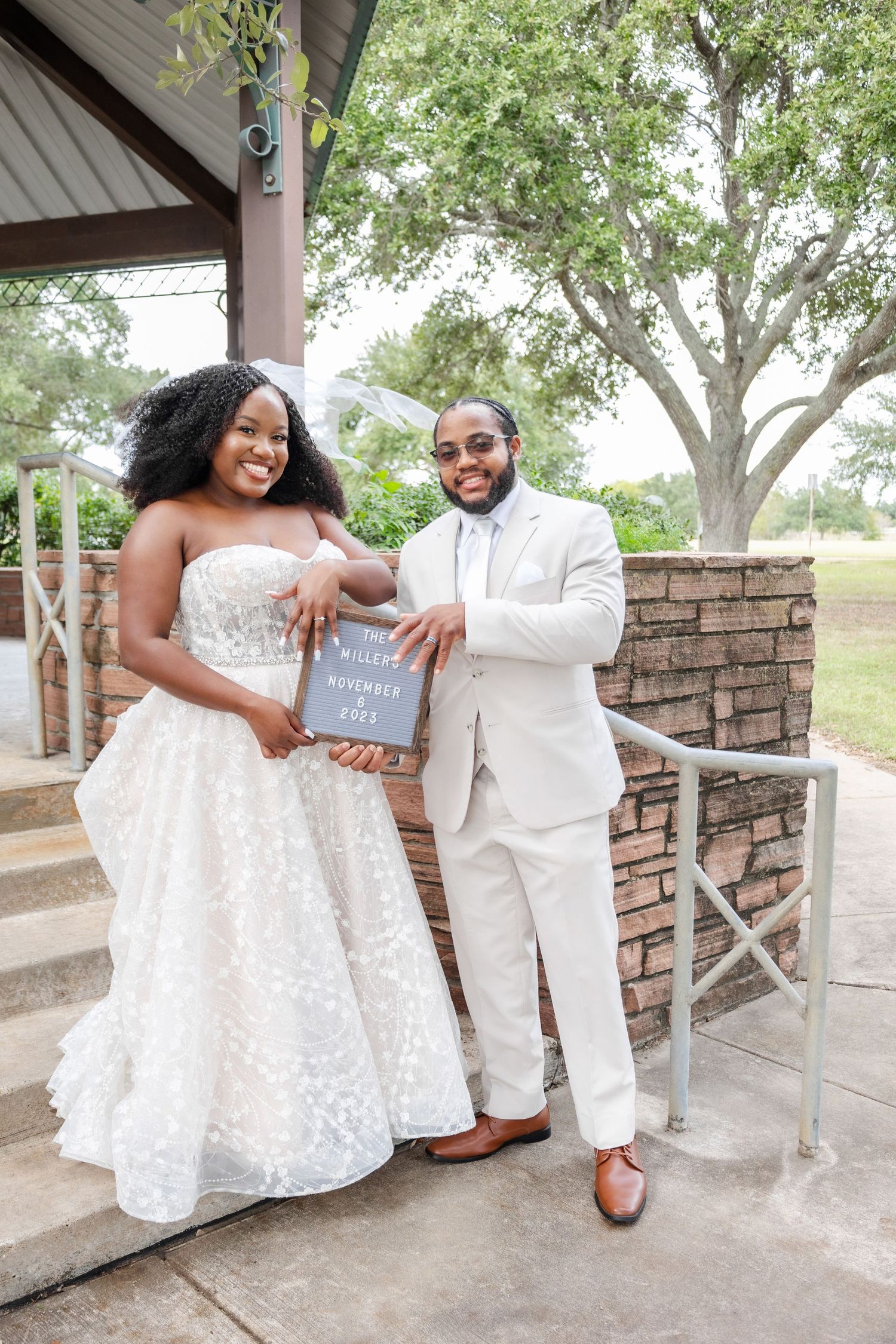 Newlyweds share candid moments during their wedding photoshoot under a covered pavilion.