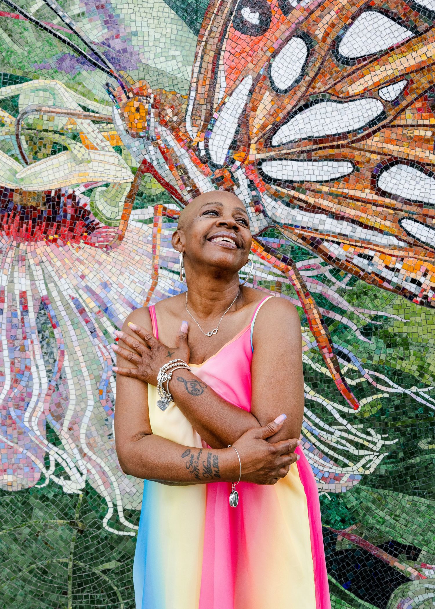 Colorful mosaic art installation with vibrant butterfly wings featuring orange, pink, and blue geometric patterns.