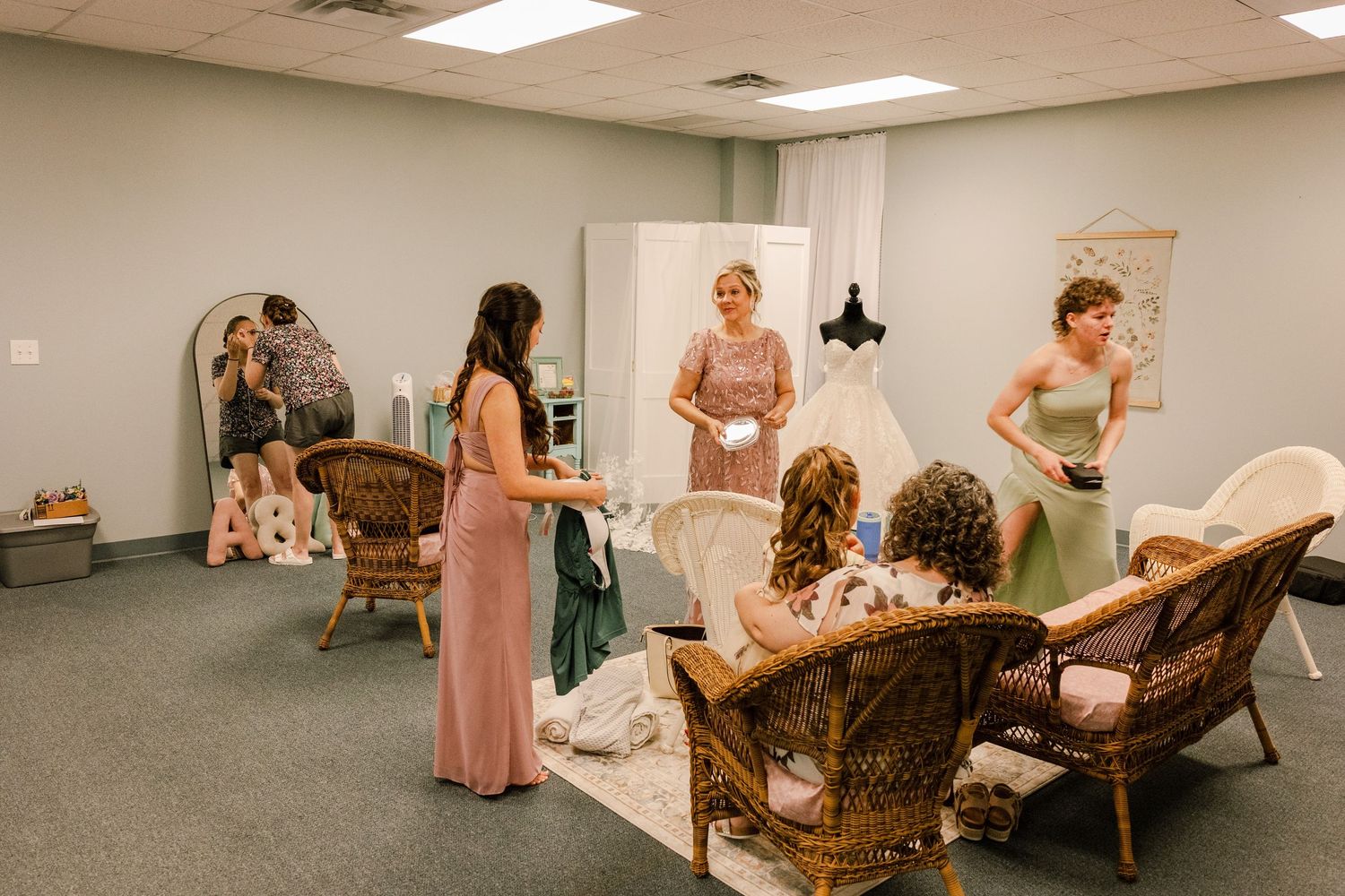 Bridal party in pink dresses relaxes in dressing room before wedding ceremony.