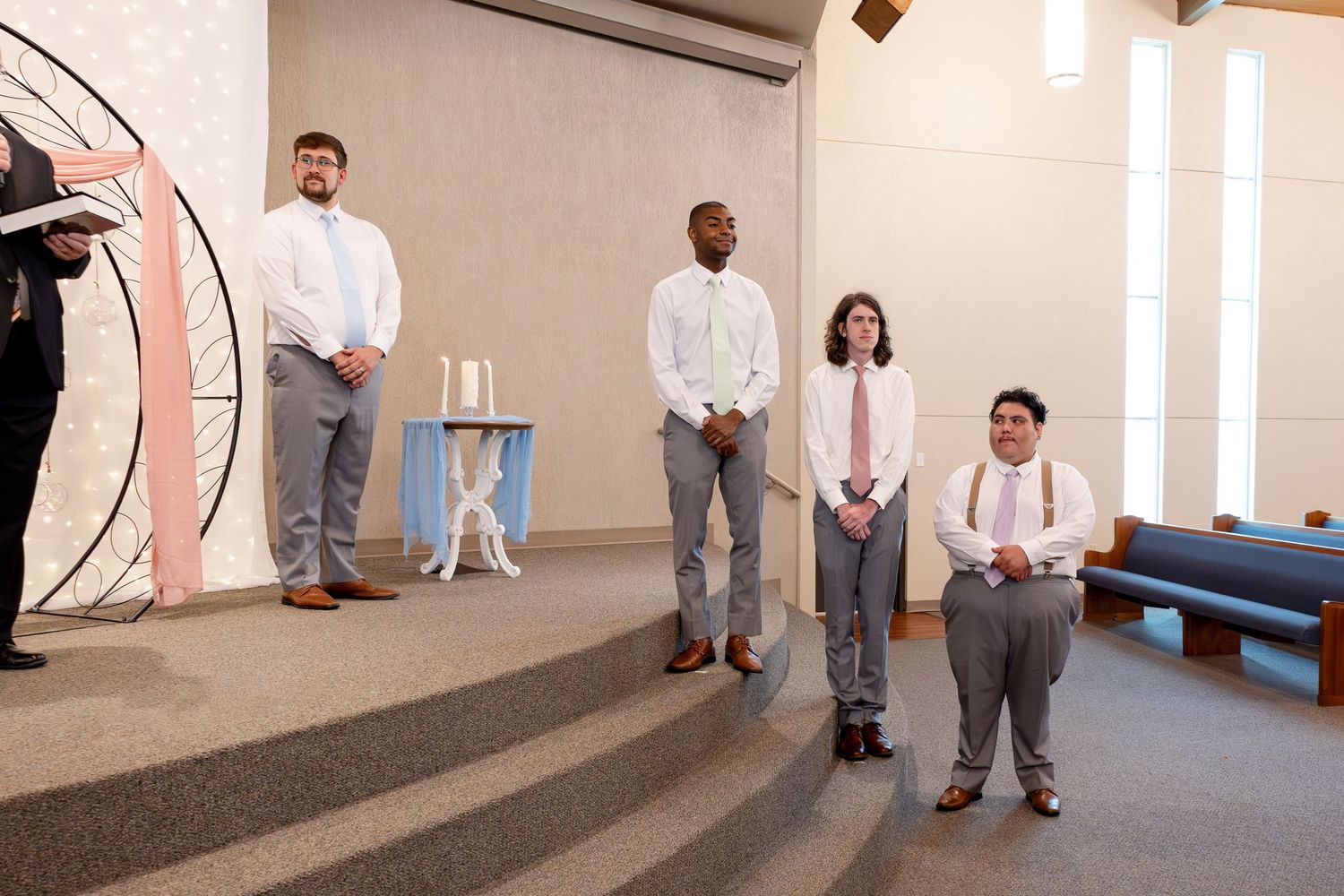 Wedding party members stand in a church hallway before the ceremony.