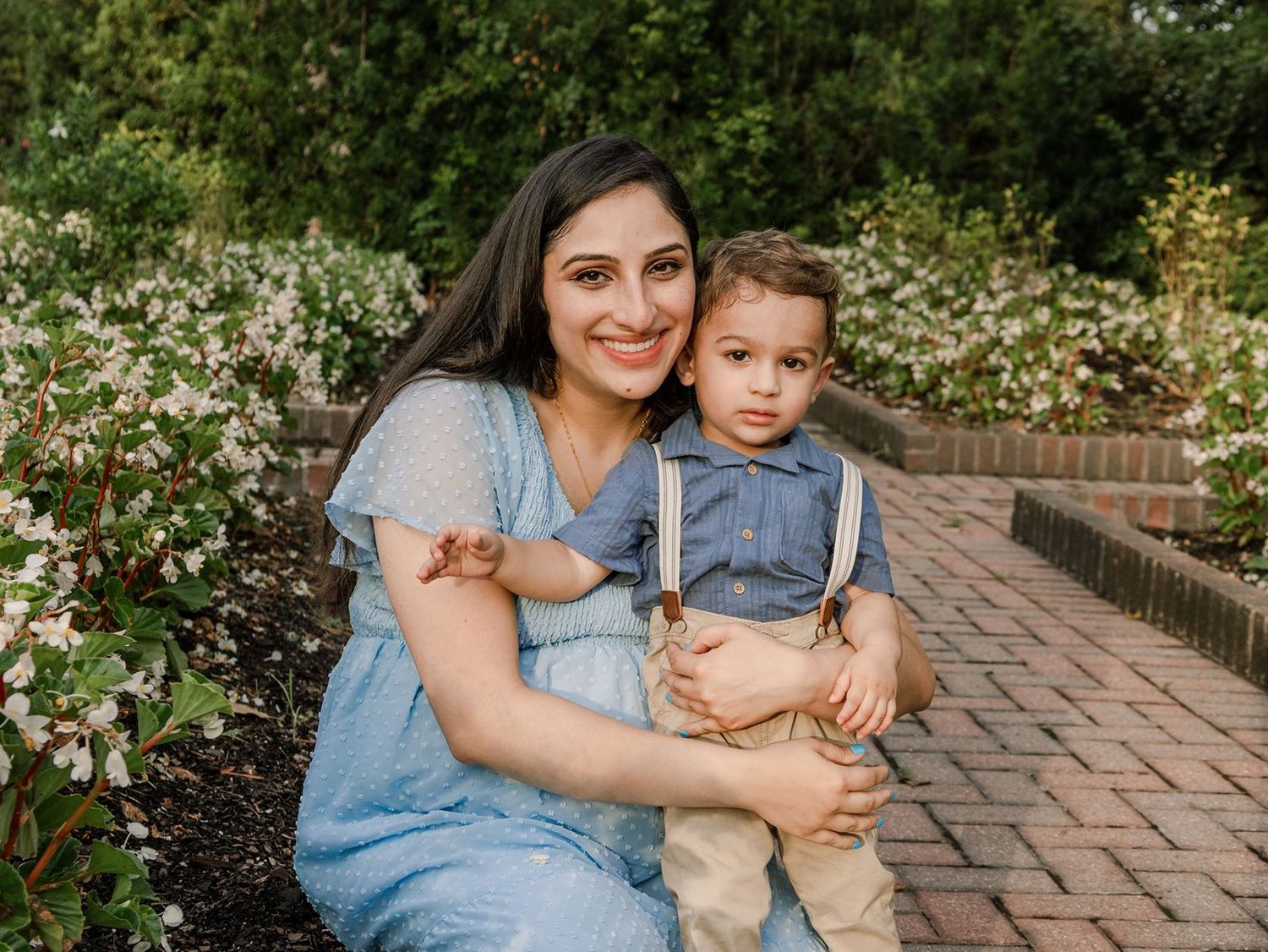 A series of outdoor family portraits on brick pathways featuring a parent and child wearing coordinating blue and beige outfits.