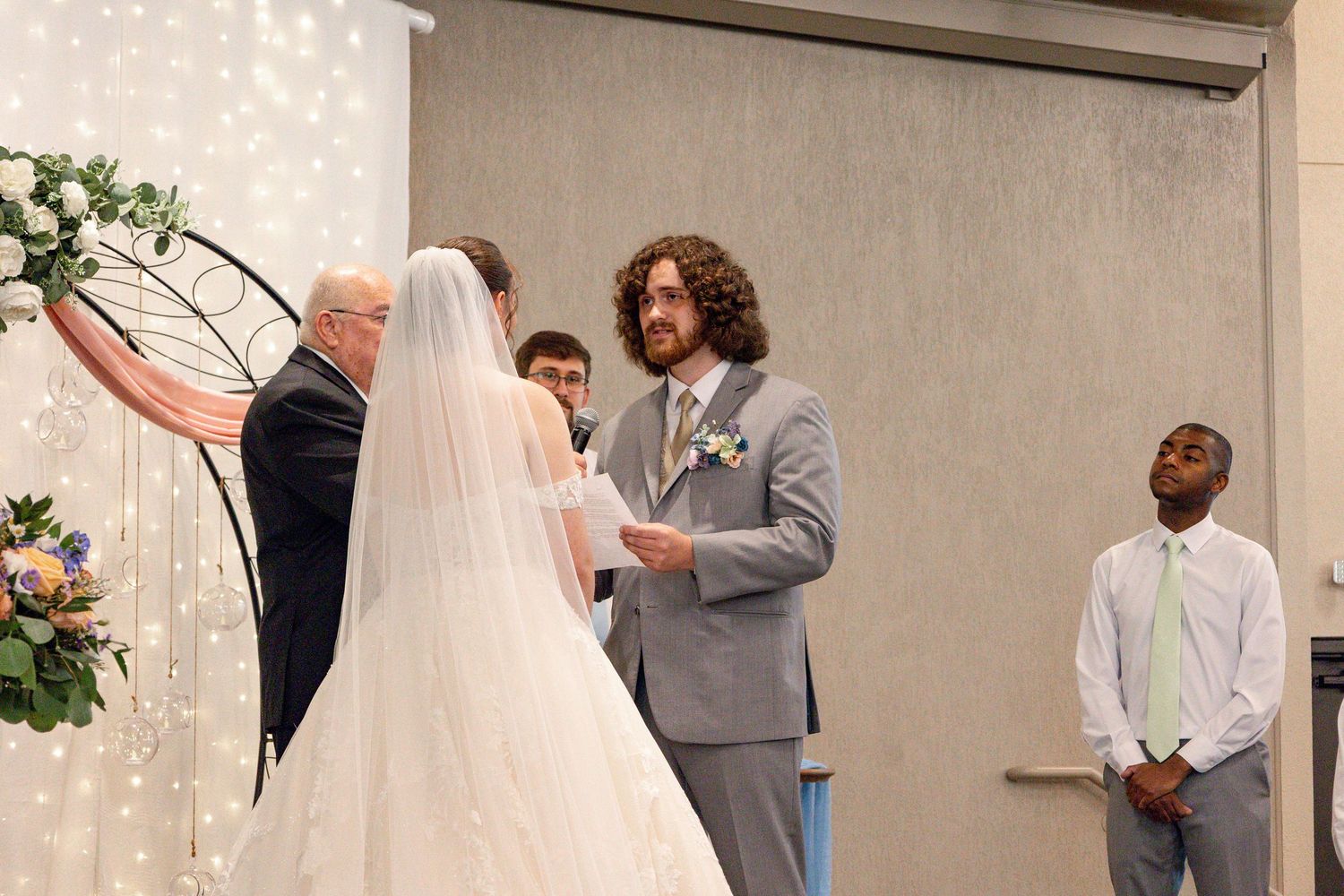 Altar ceremony scene with decorative arch and twinkling light wall backdrop.