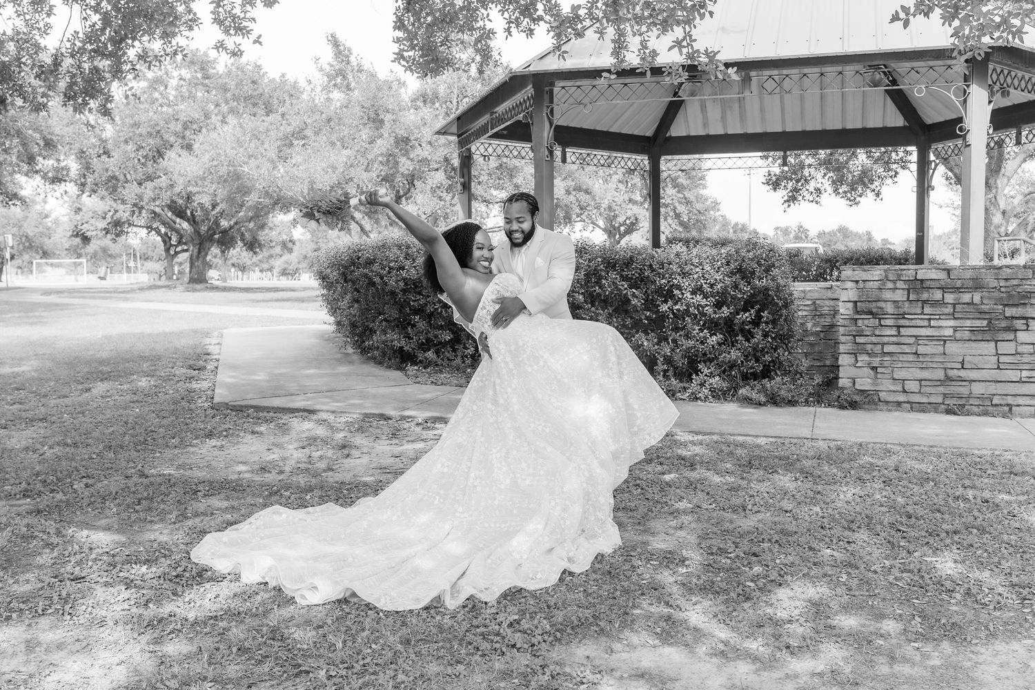 A wedding couple shares romantic moments in an outdoor garden setting with beautiful natural scenery.