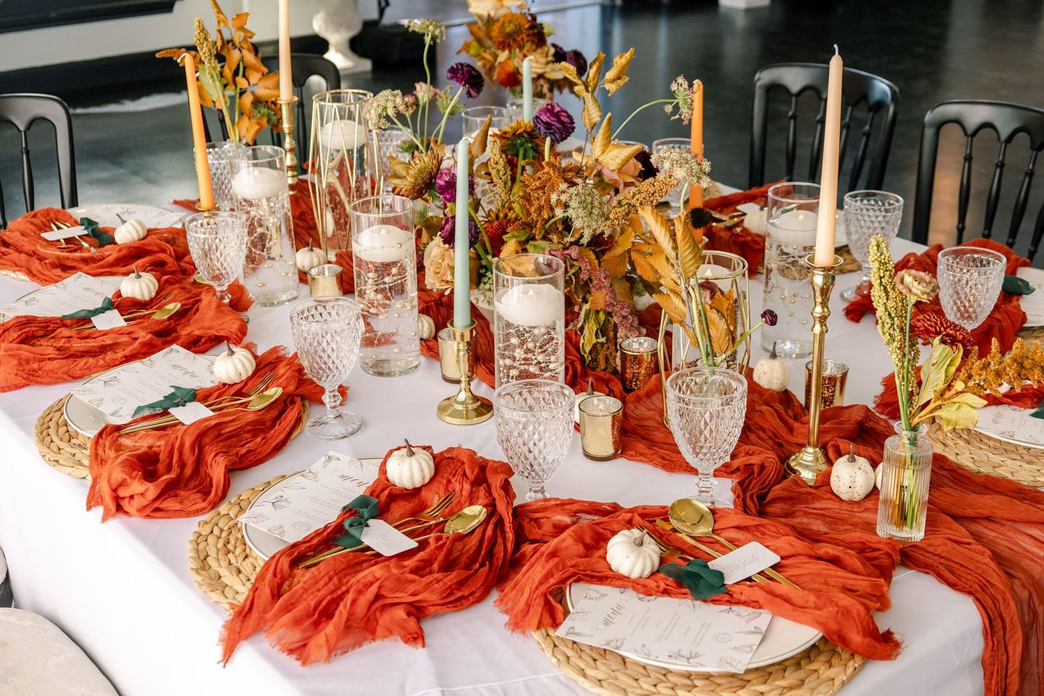 Elegant table settings with red table linens, gold accents, and crystal glassware create a luxurious dining atmosphere.