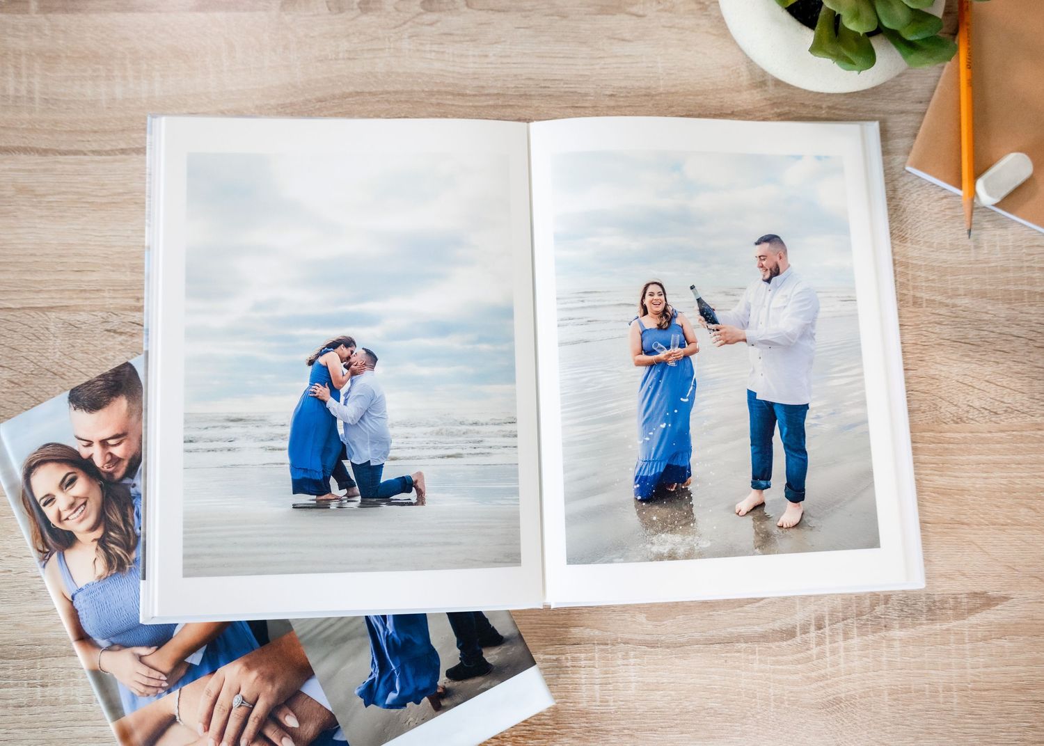 A series of romantic engagement photos displayed as a horizontal layout of photo album pages on a wooden surface.