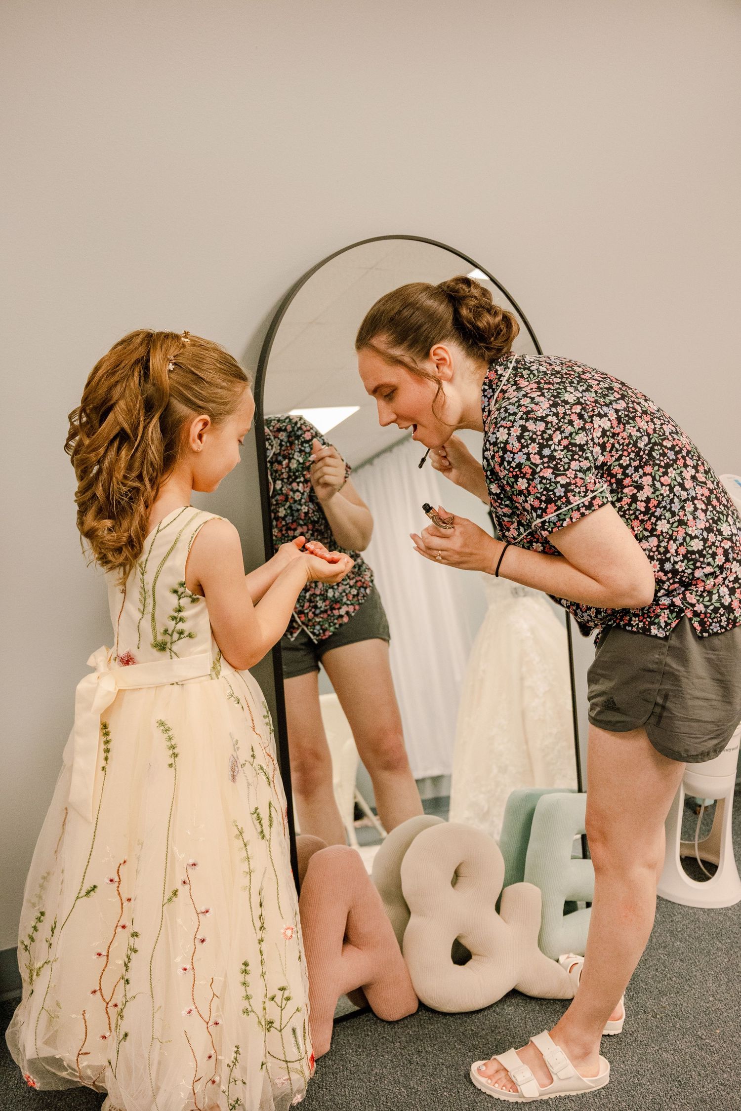 Wedding party members interacting playfully with decorative foam letters on the floor.