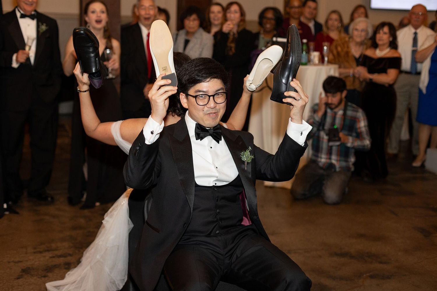 Wedding guests dance and celebrate on a rustic dance floor during an evening reception celebration.