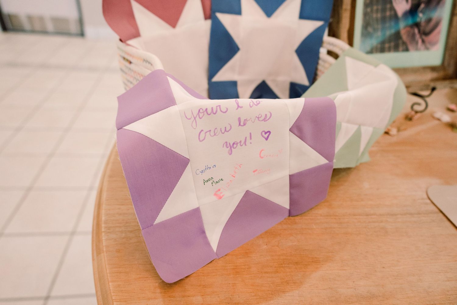 Star-shaped paper decorations in purple and white displayed on a wooden surface.