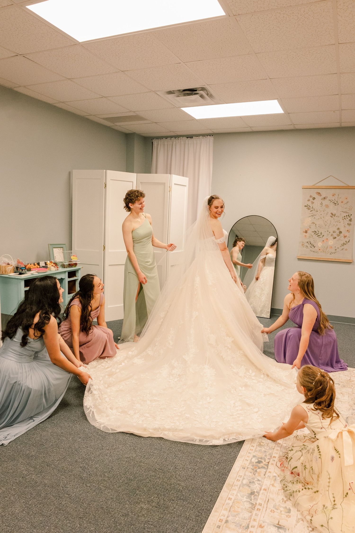 Wedding party members spread out a dramatic cathedral-length train of a white wedding gown.