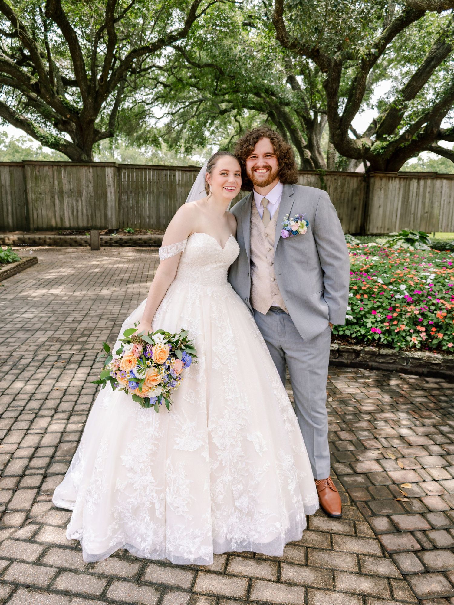 Intimate wedding portraits in a garden setting with white dress and gray suit.