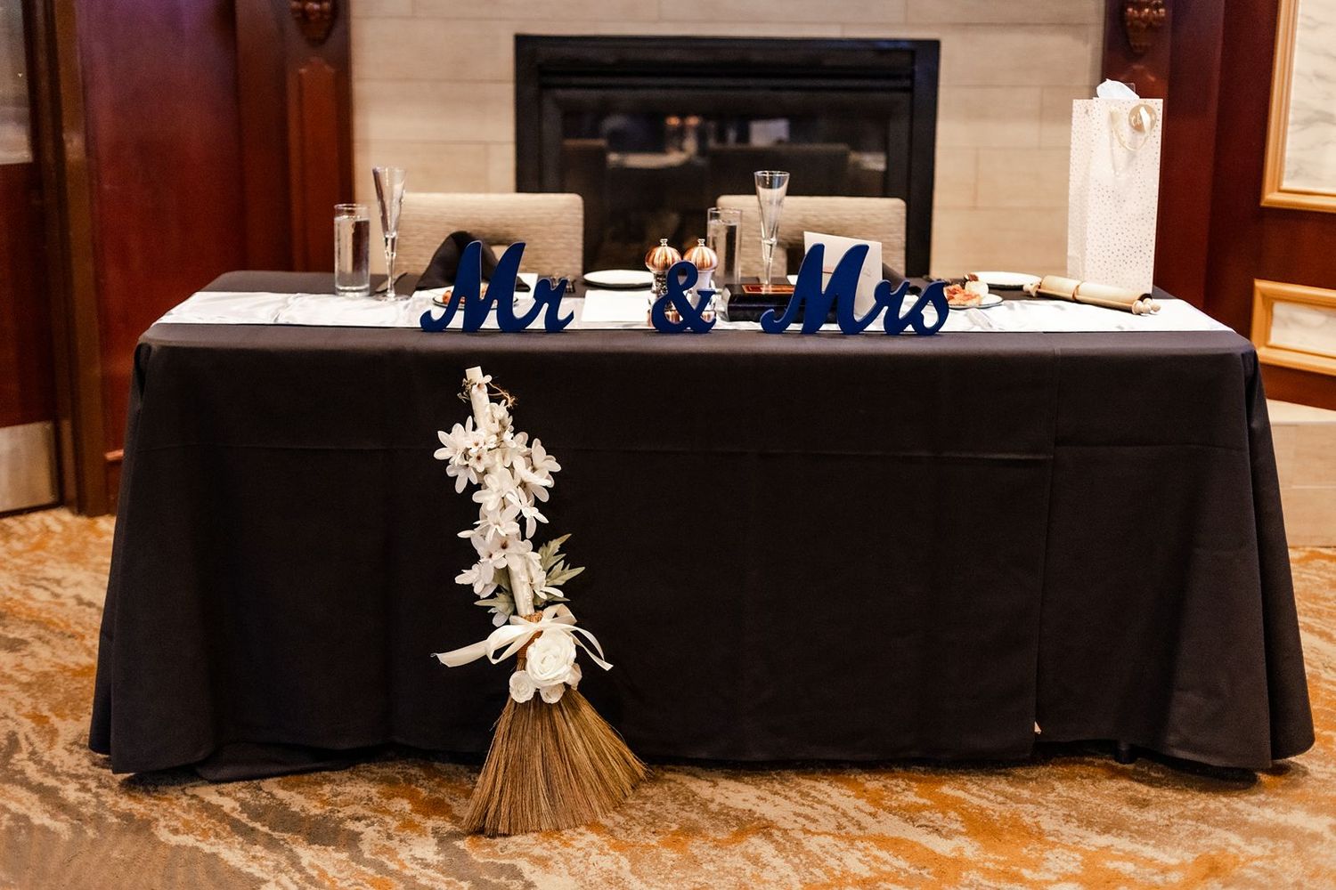 Mr. and Mrs. sweetheart table with black linen and bridal bouquet at wedding reception.
