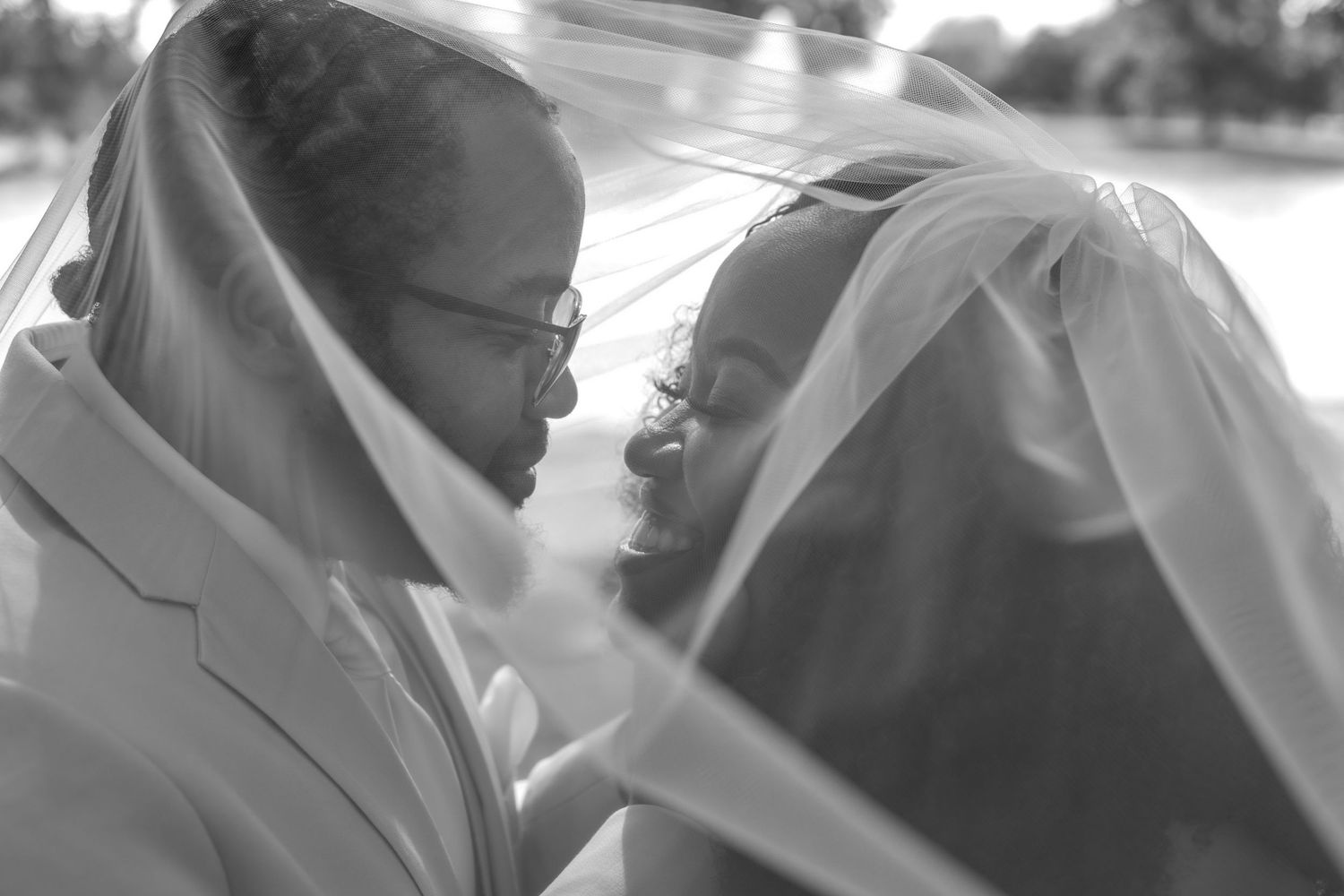 Black and white wedding portraits showing tender moments between newlyweds in an outdoor setting.
