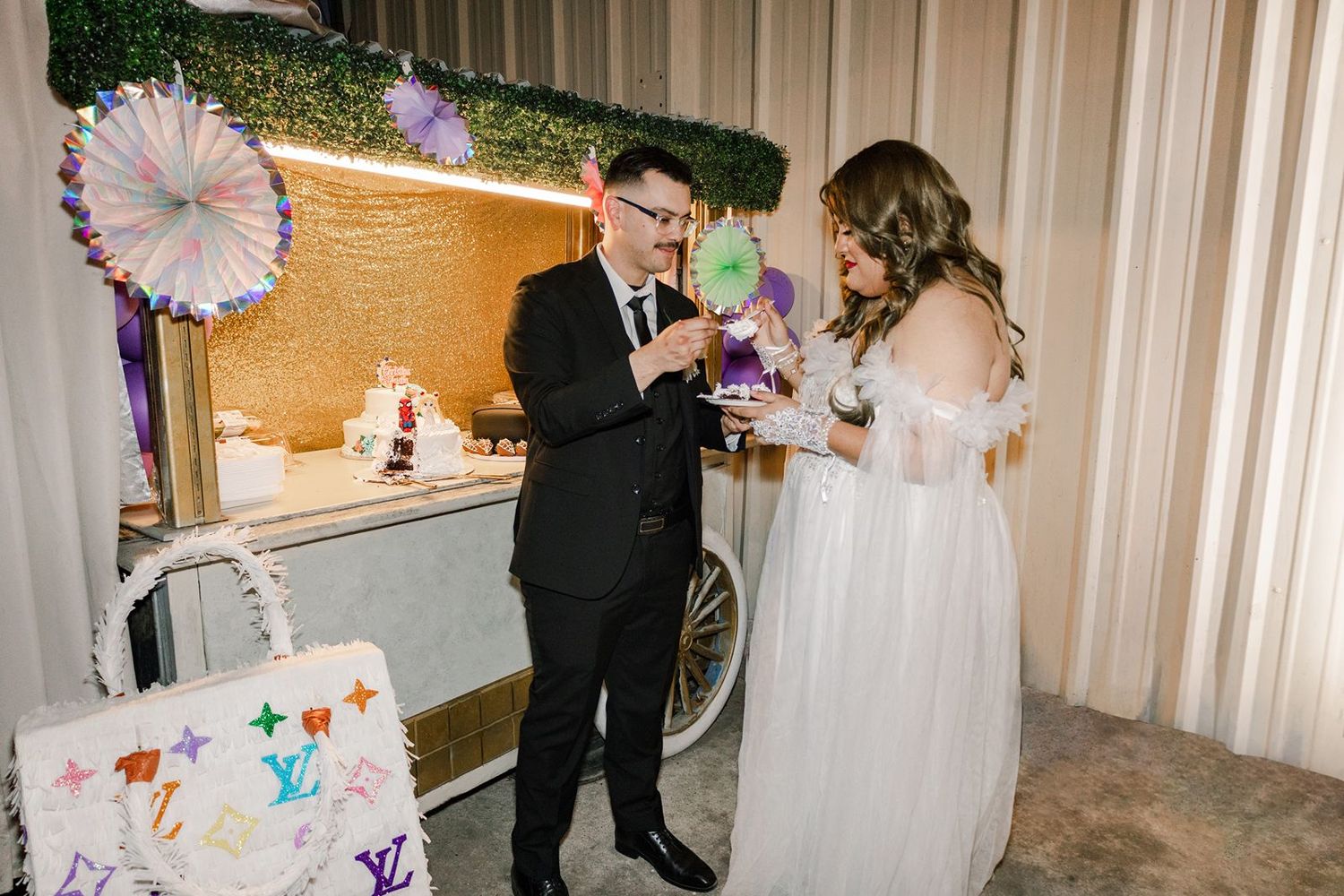 Bride and groom cutting a Louis Vuitton themed wedding cake at elegant reception venue.