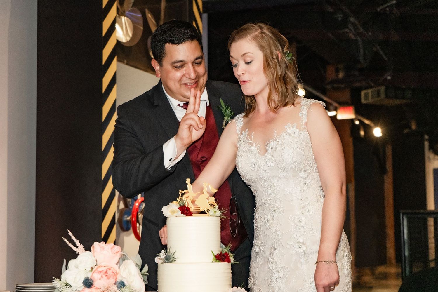 A couple shares an intimate moment during their wedding reception as they cut into their cake together.