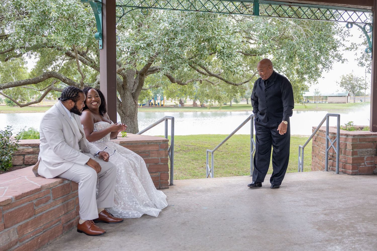 A couple shares a romantic moment under a covered patio area during their wedding celebration.