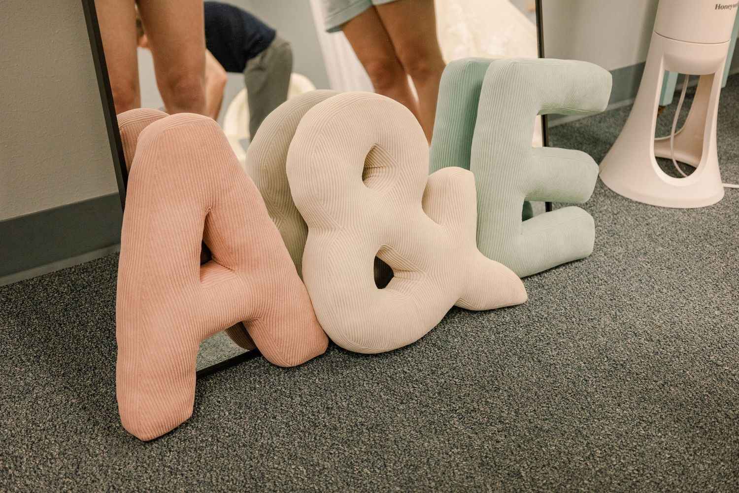 Large decorative foam letters spelling 'LOVE' arranged on grey carpeted floor.