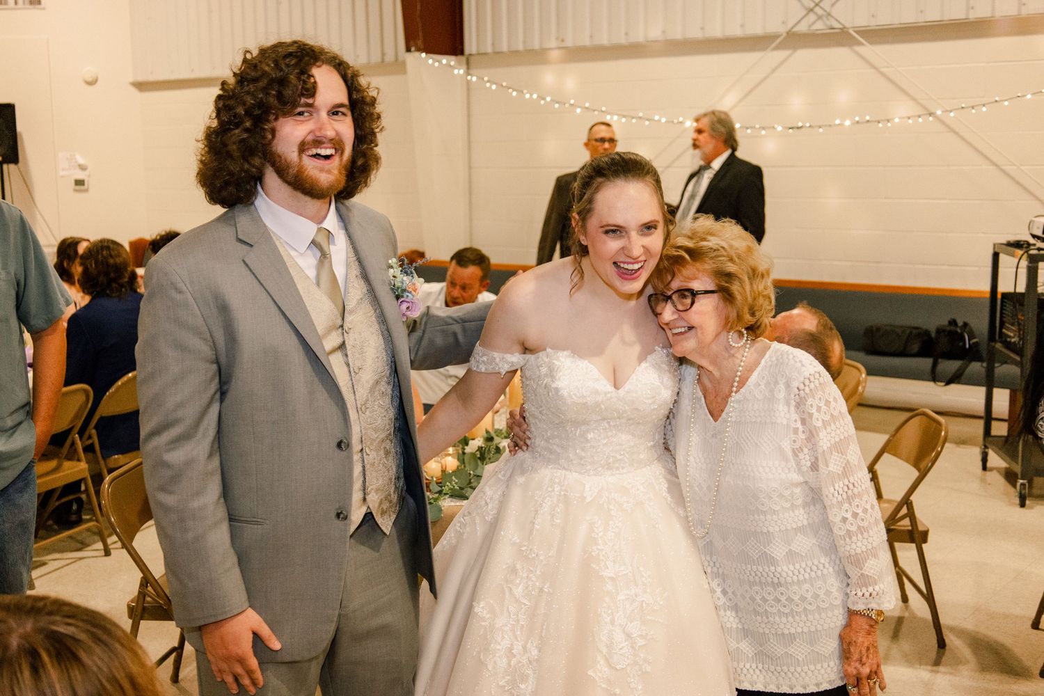 Wedding party members pose together during reception celebration.