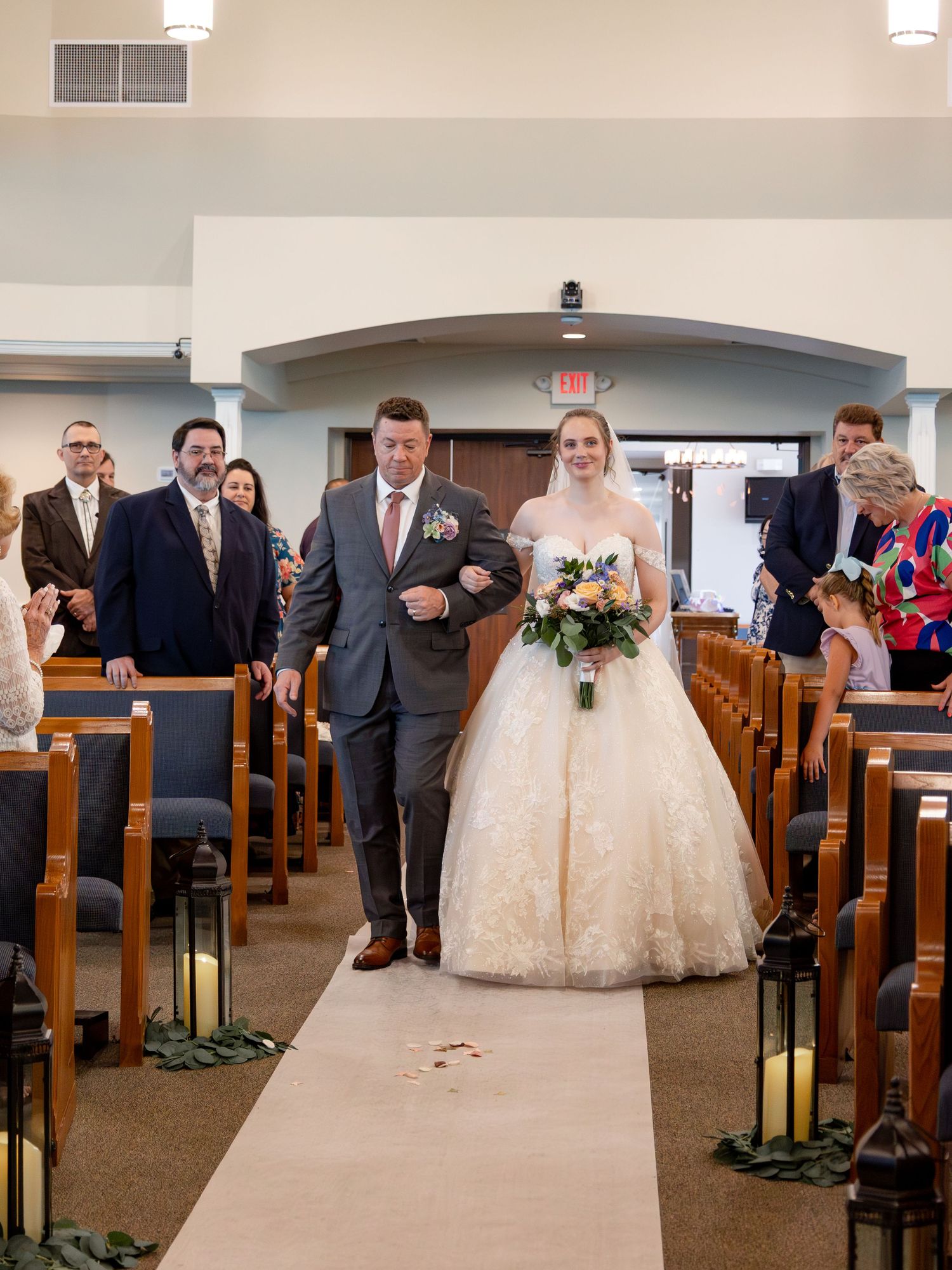 Wedding ceremony procession in a contemporary church sanctuary with elegant decor.