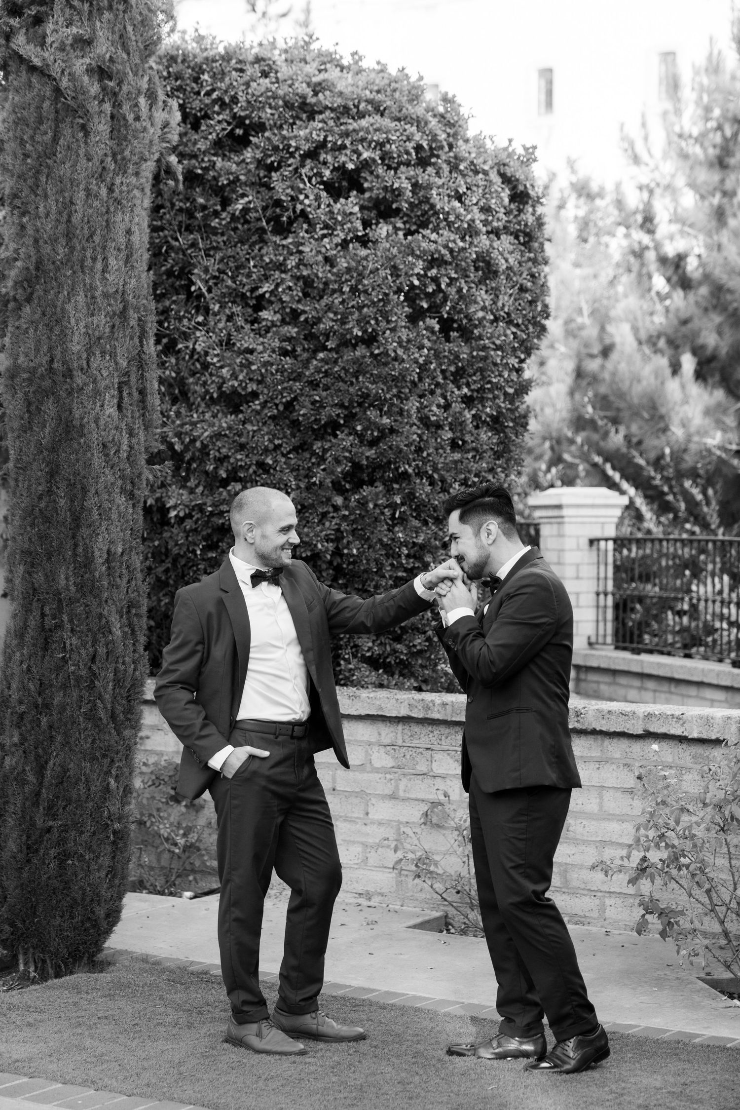 Two people in formal wear sharing a drink and conversation on an elegant stone walkway.