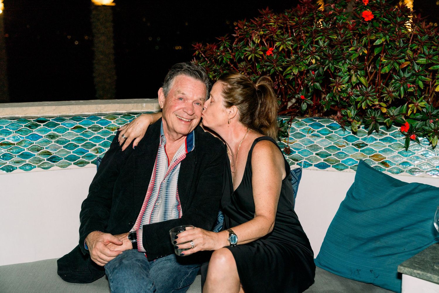 Couple shares an intimate moment while relaxing on outdoor lounge furniture.