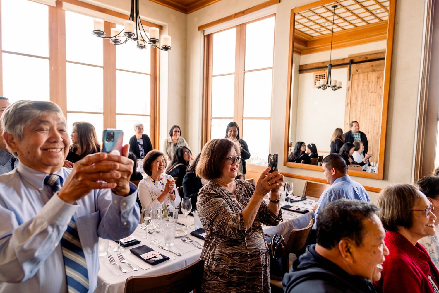 Wedding guests raise their glasses in a toast during the reception dinner.