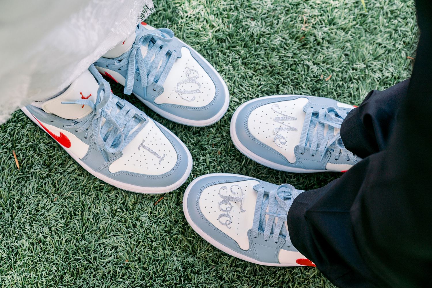 A pair of grey and white Nike Air Jordan sneakers photographed on green artificial turf.